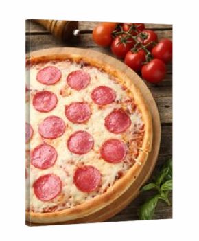 Delicious pepperoni pizza and ingredients on wooden table, closeup