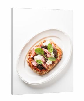 delicious oval flatbread pizza with ricotta cheese, prosciutto, spinach, and morel mushrooms on a white oval plate.