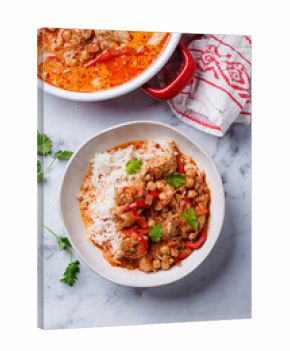 Tikka masala with chicken, chickpeas and rice in bowl.