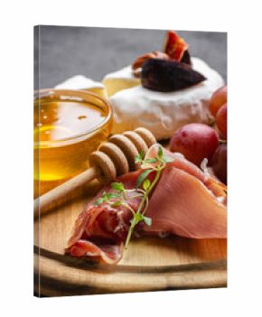 Appetizer board with meat, cheese, grapes, nuts and fresh figs.