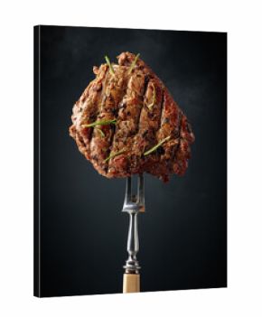 Grilled beef steak on a fork.