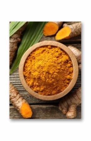 Turmeric powder in bowl, roots and leaves on wooden table, flat lay