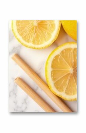 Two Reusable Bamboo Straws and Lemon Slices on a Marble Countertop