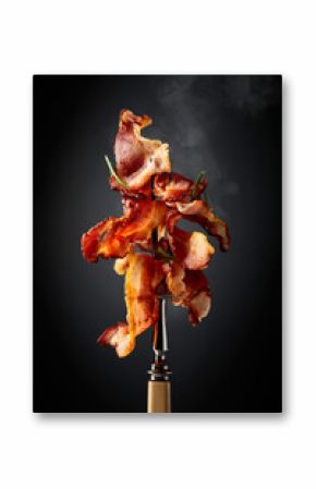 Fried bacon with rosemary on a fork.