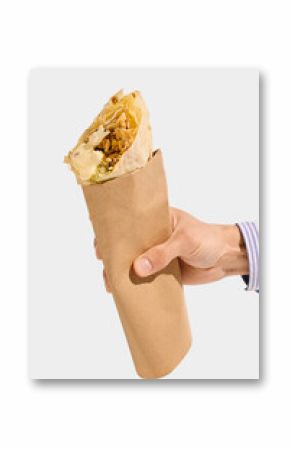 Shawarma roll with grilled meat, white sauce, cabbage, and flatbread held in brown paper sleeve, viewed from hand against white background. Concept of shawarma, wrap, meat, takeaway, street food