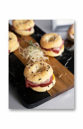 Gourmet catering service for social events. Closeup view of mini pastrami bagels displayed in a dark marble board