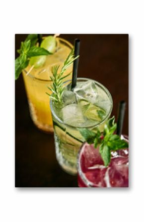Colorful refreshing cocktails with mint and rosemary garnishes on table