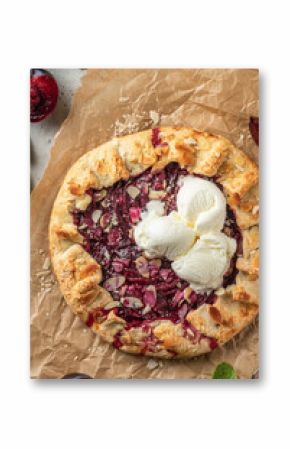 French Galette or pie with plums and almonds served with ice cream scoops on parchment paper background close up. Summer traditional homemade sweet pastries