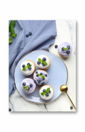 Plate of delicious cupcakes with blueberries and mint on white background