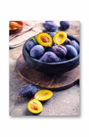 Freshly picked ripe plums (Zwetschgen) fruits in bowl with sugar and cinnamon. Prepared for baking a cake or making marmalade