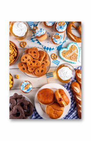 Oktoberfest festive food, with various snacks, sweets, desserts, pretzels, beer jelly, gingerbread cookies hearts, salted crackers, popcorn, jam donuts, cupcakes. Oktoberfest brunch menu background