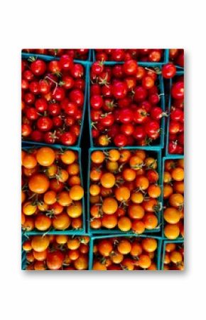 tiny hybrid yellow and red tomatoes in square green plastic baso