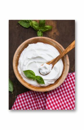 Plain greek yogurt in wooden bowl  on wooden board