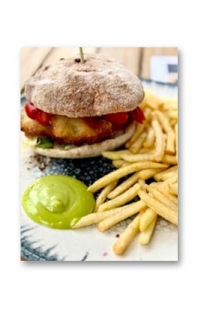 Pyszny fishburger podawany frytkami i sosem