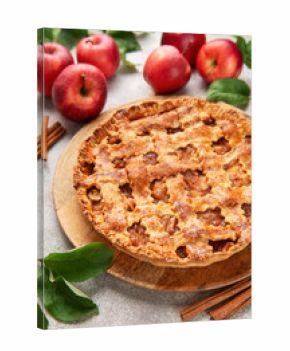 Freshly baked apple pie decorated with cinnamon sticks and apple leaves