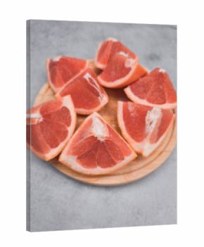 Fresh grapefruit wedges arranged on wooden plate, capturing the essence of citrus delight