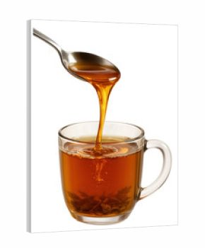 Golden honey dripping from a spoon into a steaming mug of herbal tea.