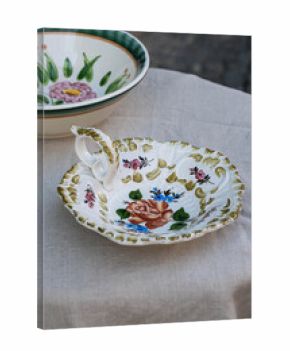 Vintage Italian plate with beautiful flower pattern on linen tablecloth.