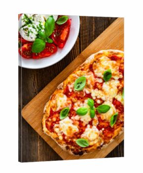 Pinsa Margherita and caprese burrata salad on wooden background