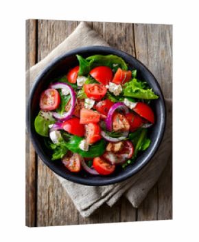A colorful salad mix nestled in a dark bowl, exuding freshness and zest.