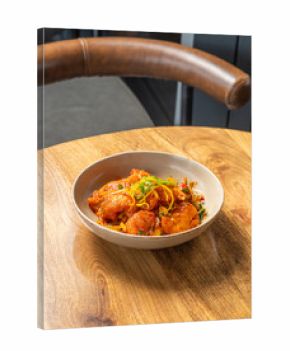 Authentic Chinese, stir fried fish plated in a bowl kept on a wooden table