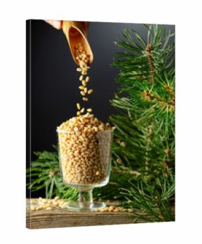 Pine nuts is poured in a glass bowl.