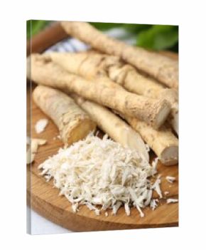 Whole and grated horseradish roots on table, closeup