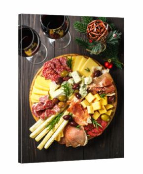 Christmas food Antipasto with red wine. Cheese and meat with olives at serving board. Romantic christmas or New Year dinner for couple.