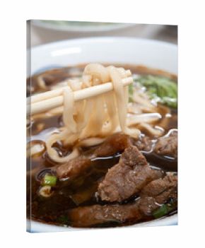 Taiwanese beef noodle soup, famous food in a bowl on wooden table.