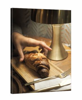 Enjoying a fresh croissant at a cozy cafe table