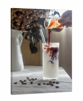 iced latte coffee on table, Espresso coffee is being poured into a glass filled with milk and ice.