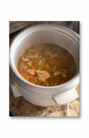A view of chicken soup cooking in a rice cooker.