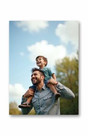 Happy father carries son on shoulders in park. Man and young boy laughing, enjoying fun time together outdoors. Cheerful kid and dad spend weekend, holiday. Family relationship concept.