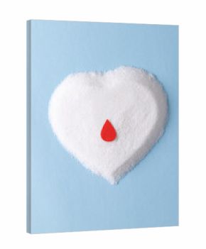 Blood drop over sugar in heart shape on blue background with copy space