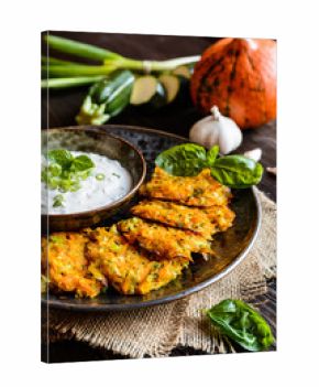 Pumpkin pancakes with zucchini and served with sour cream dip