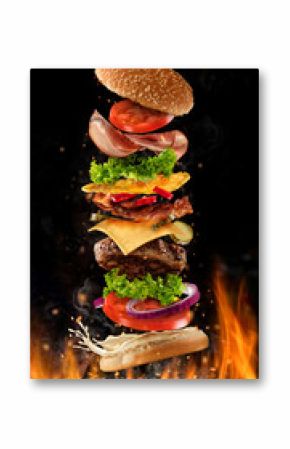 Flying burger ingredients above grill