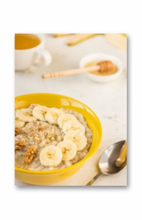 Oatmeal with banana and honey. Porridge in a yellow bowl