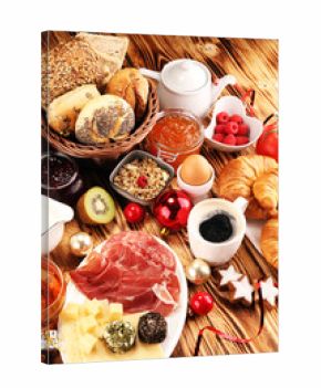 breakfast on table with bread buns, croissants, coffe and juice on christmas day. xmas holiday morning.