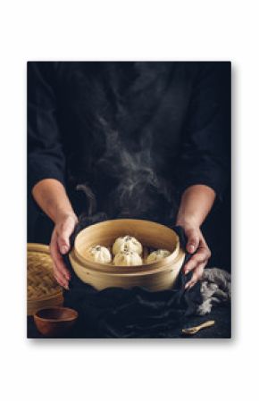 Woman presenting dim sum dumplings in steamer