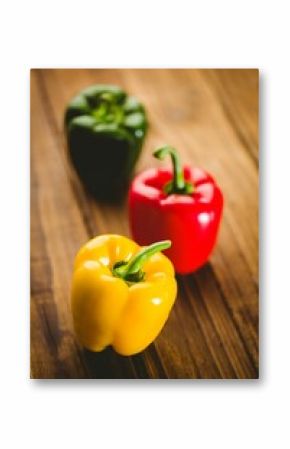 Multi colored bell peppers on wooden floor