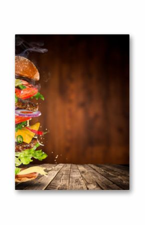 Big tasty burger with flying ingredients.