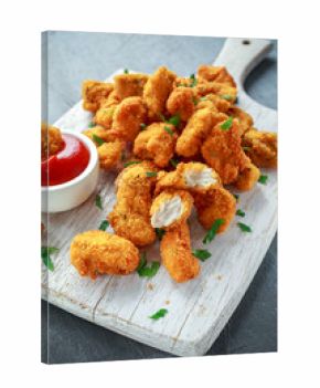 Fried crispy chicken nuggets with ketchup on white board