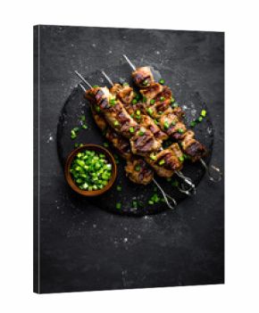Grilled meat skewers, shish kebab on black background, top view