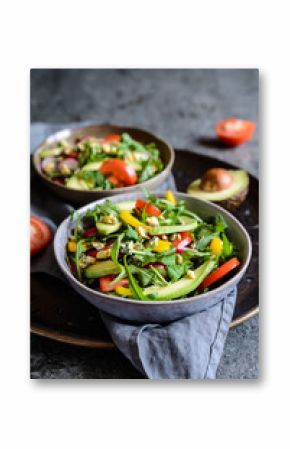 Healthy arugula salad with avocado, radish, bell pepper, tomato and Roquefort cheese