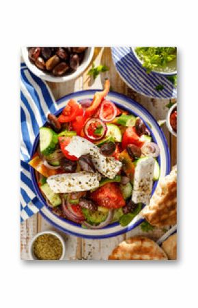 Greek salad. Traditional Greek salad consisting of fresh vegetables such as tomatoes, cucumbers, peppers, onions, oregano and olive oil, top viewl. A delicious and healthy vegetarian dish
