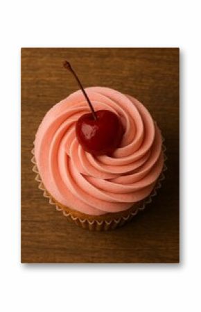 Pink frosted cupcake with cherry on wooden surface