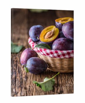 Plums. Fresh juicy plums in a bowl on a wooden or concrete board.