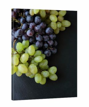 two branches of grapes on slate