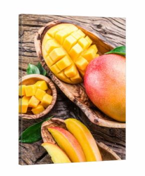 Mango fruit and mango cubes on the wooden table.