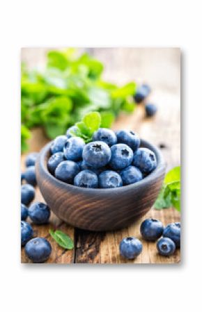 Fresh blueberries in bowl on wooden table